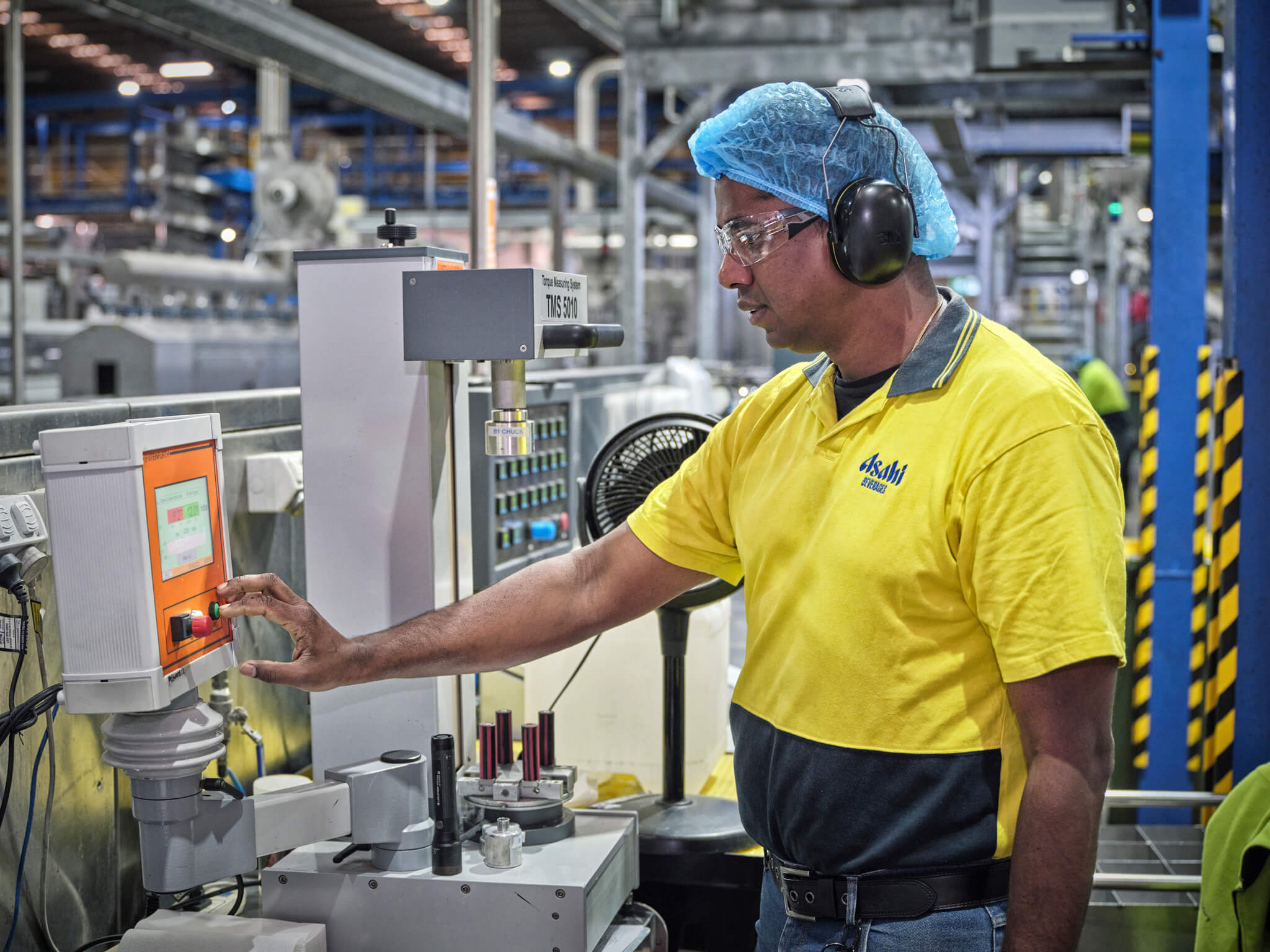 Asahi Global Procurement employee operating machinery in a manufacturing facility
